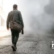 A man walking down a smoky path carrying a bag that reads altcoins. Happy_Coin_News